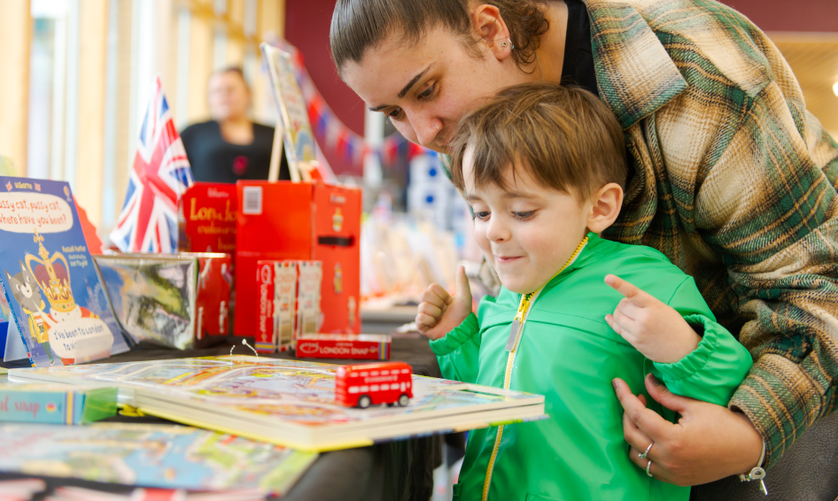 A child and adult playing a game with a London bus